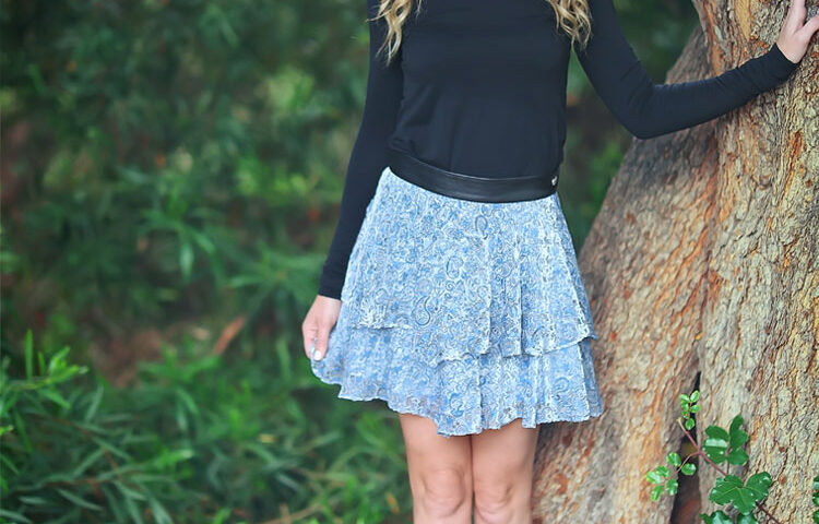 Smiling blonde woman leaning on tree