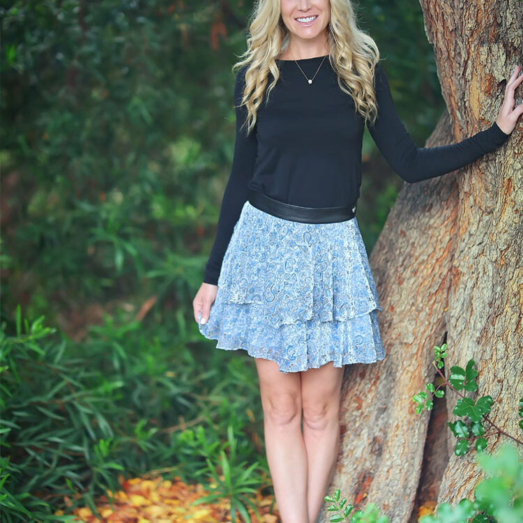 Smiling blonde woman leaning on tree
