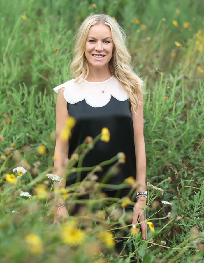 Smiling blonde woman in wildflower field